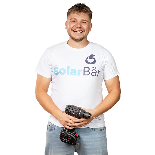Junger Elektroinstallateur mit Solarbär T-Shirt und Akkuschrauber in der Hand